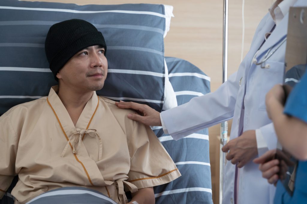 A middle-aged Asian man was treated for cancer undergoing chemotherapy with his doctor encouraging.